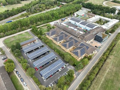 Sun-powered carport beside a research lab topped with solar panels