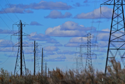 Electric towers lined up under the blue calm sky