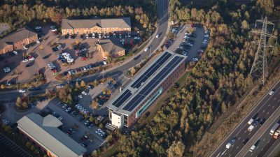 Hotel with full rooftop solar array located near woodland and motorway